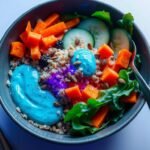 Quinoa and spinach bowl with vibrant spirulina dressing and pumpkin seeds