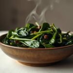 Okinawan glazed spinach with orange miso glaze in a ceramic bowl